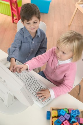 Boy Helping Girl Use Computer